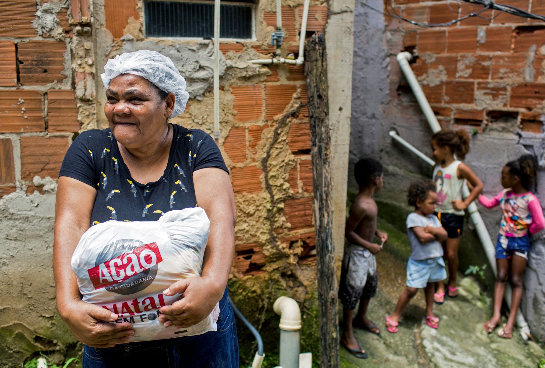 Moradora de Caxias, na Baixada Fluminense, com cesta distribuída pela Ação da Cidadania: combate à fome e à pobreza em retrocesso (Foto: Daniel Ramalho / AFP - 21/12/2021)