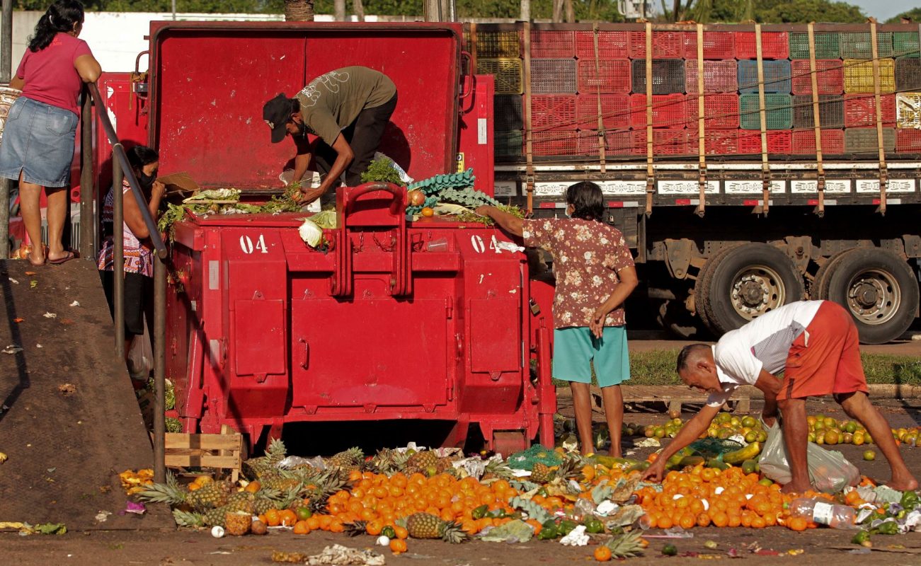 Moradores de Belém buscam no lixo sobras de comida após feira livre: fome faz parte dos retrocessos do Brasil para o desenvolvimento sustentável (Foto: Raimundo Pacco / AFP - 04/11/21)