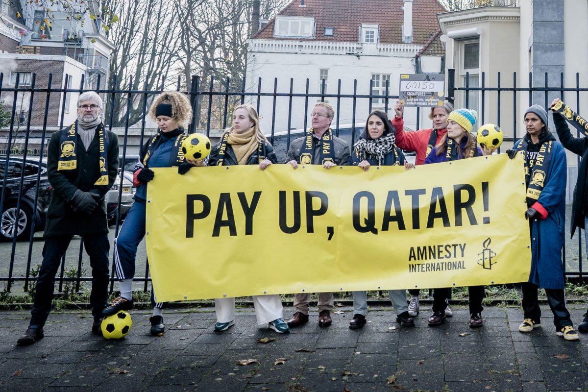 ntegrantes da Anistia Internacional fazem protesto na Holanda para reivindicar que o Catar indenize trabalhadores migrantes demitidos ou mortos durante o trabalho: sportswashing (Foto: Bart Maat / ANP / AFP - 29/11/2022)