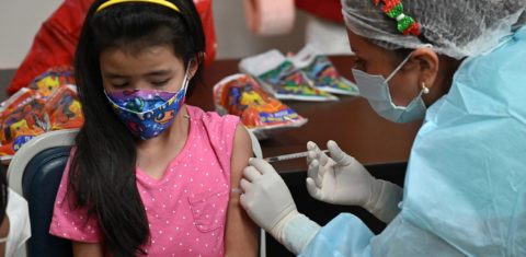 Menina boliviana recebe a primeira dose da vacina da Pfizer contra a covid-19. Foto Aizar Raldez/AFP