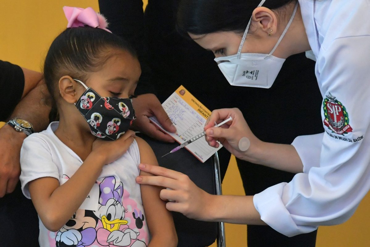 Pandemia: menina recebe a primeira dose da vacina Pfizer-BioNTech contra covid-19, no Hospital das Clínicas de São Paulo. Foto Nelson Almeida/AFP. Janeiro/2022