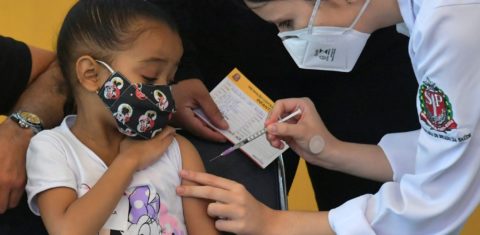 Pandemia: menina recebe a primeira dose da vacina Pfizer-BioNTech contra covid-19, no Hospital das Clínicas de São Paulo. Foto Nelson Almeida/AFP. Janeiro/2022