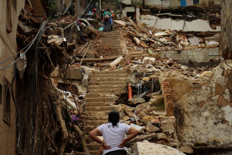Vítima da destruição em Petrópolis observa as ruínas e o trabalho dos bombeiros. Número de mortos na região já passa de 200. Foto Gabriel Alves/Controluce via AFP