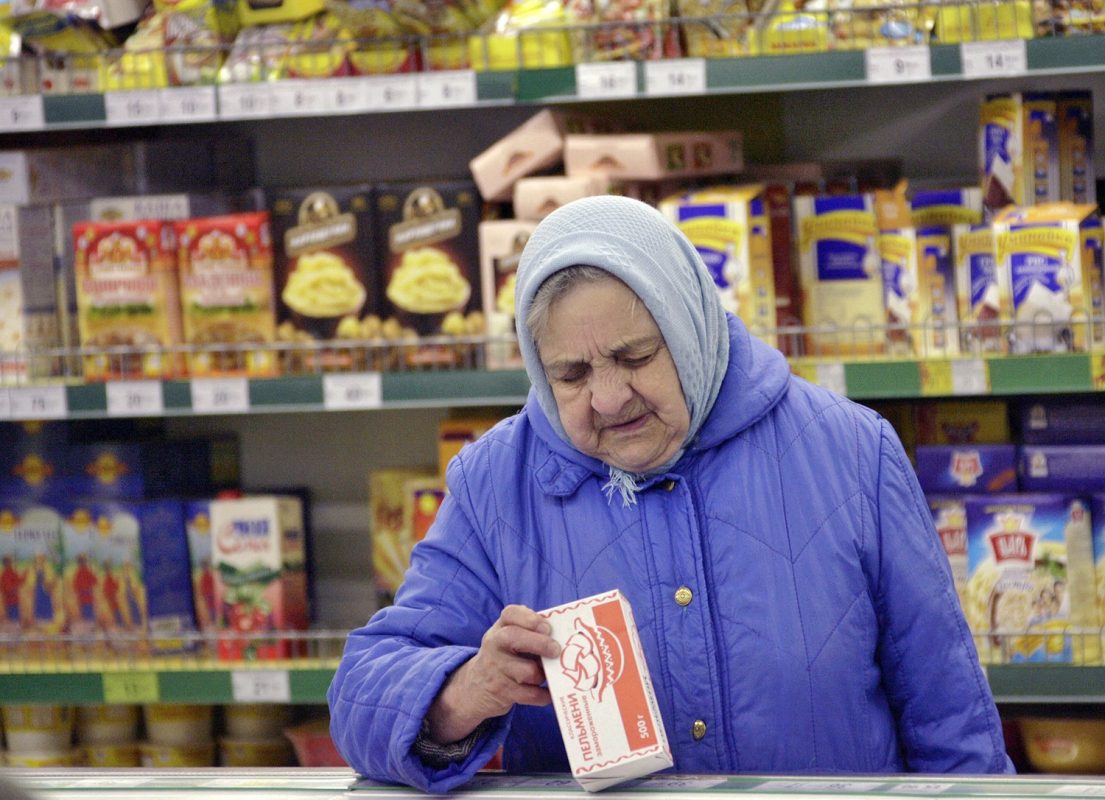Disparada de preços dos alimentos bate recorde e atinge o mundo todo. Em um supermercado, em Moscou, mulher confere a etiqueta de um produto. Foto Krivobok Ruslan/Sputnik via AFP