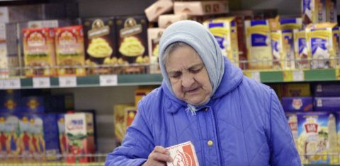 Disparada de preços dos alimentos bate recorde e atinge o mundo todo. Em um supermercado, em Moscou, mulher confere a etiqueta de um produto. Foto Krivobok Ruslan/Sputnik via AFP