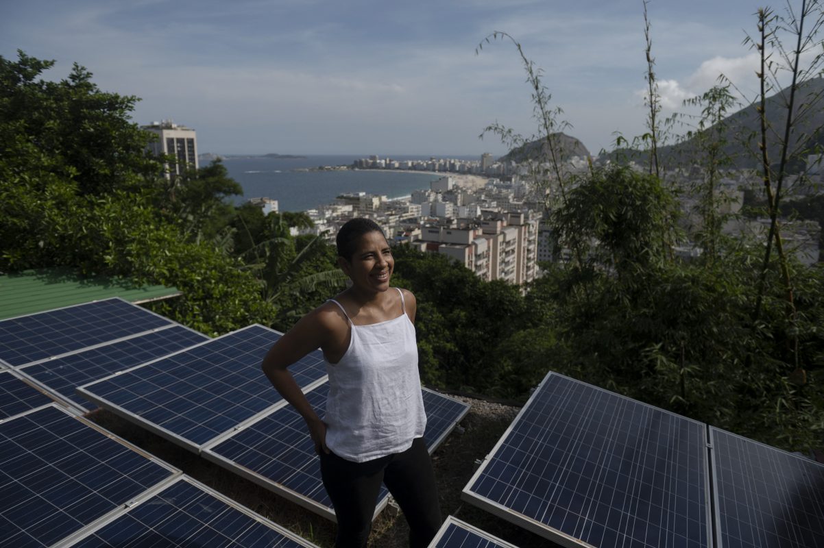 A colombiana Bibiana Angel, proprietária do hostel Eco Pousada Estrelas da Babilonia, posa em seu telhado coberto por painéis solares e com vista para a praia de Copacabana, no Morro da Babilônia, no Rio de Janeiro. Foto Mauro Pimentel/AFP