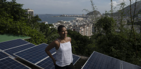 A colombiana Bibiana Angel, proprietária do hostel Eco Pousada Estrelas da Babilonia, posa em seu telhado coberto por painéis solares e com vista para a praia de Copacabana, no Morro da Babilônia, no Rio de Janeiro. Foto Mauro Pimentel/AFP