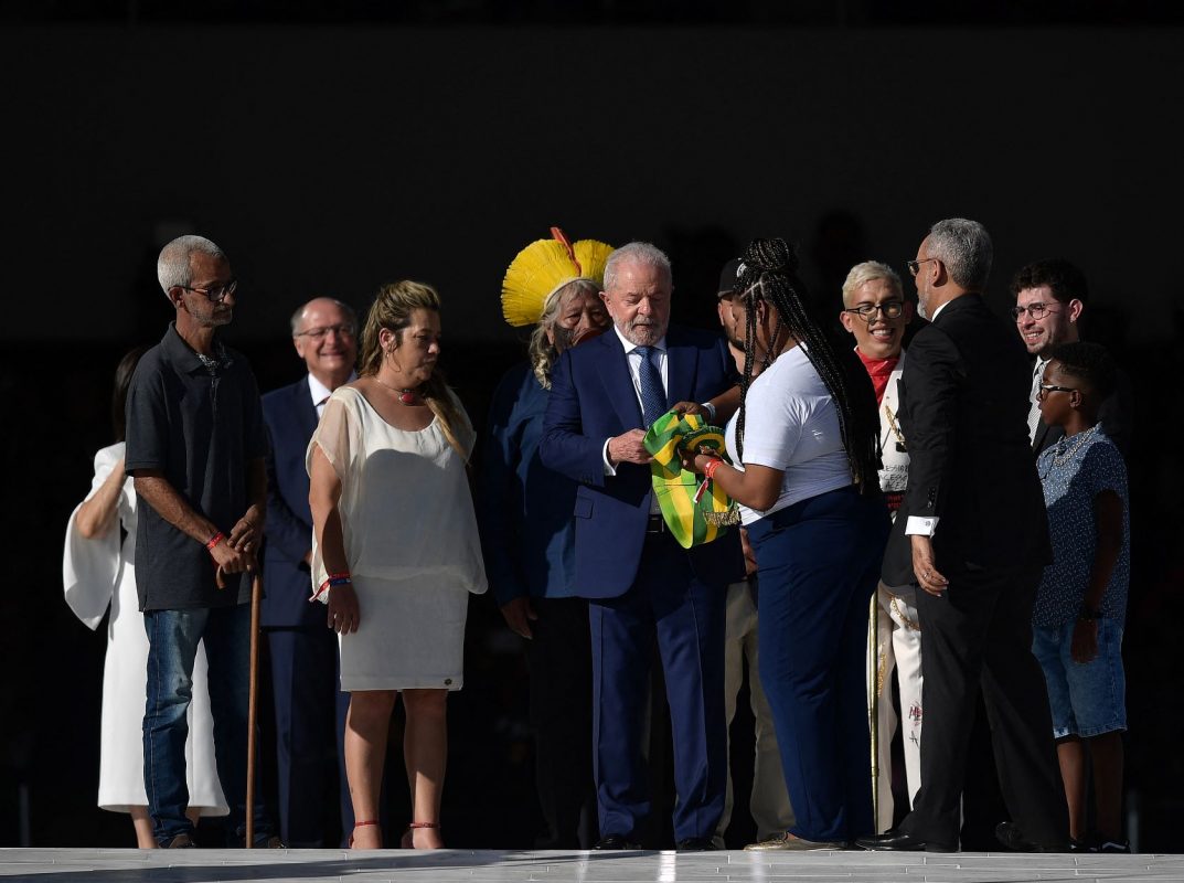 Lula recebe a faixa da catadora Aline na rampa do Planalto: prioridade no enfrentamento à desigualdade (Foto: Carl de Souza / AFP)