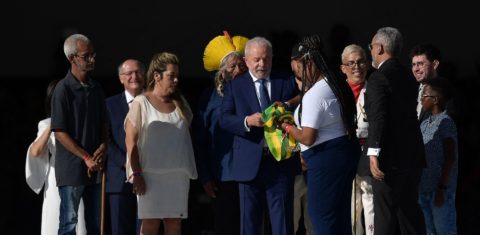 Lula recebe a faixa da catadora Aline na rampa do Planalto: prioridade no enfrentamento à desigualdade (Foto: Carl de Souza / AFP)