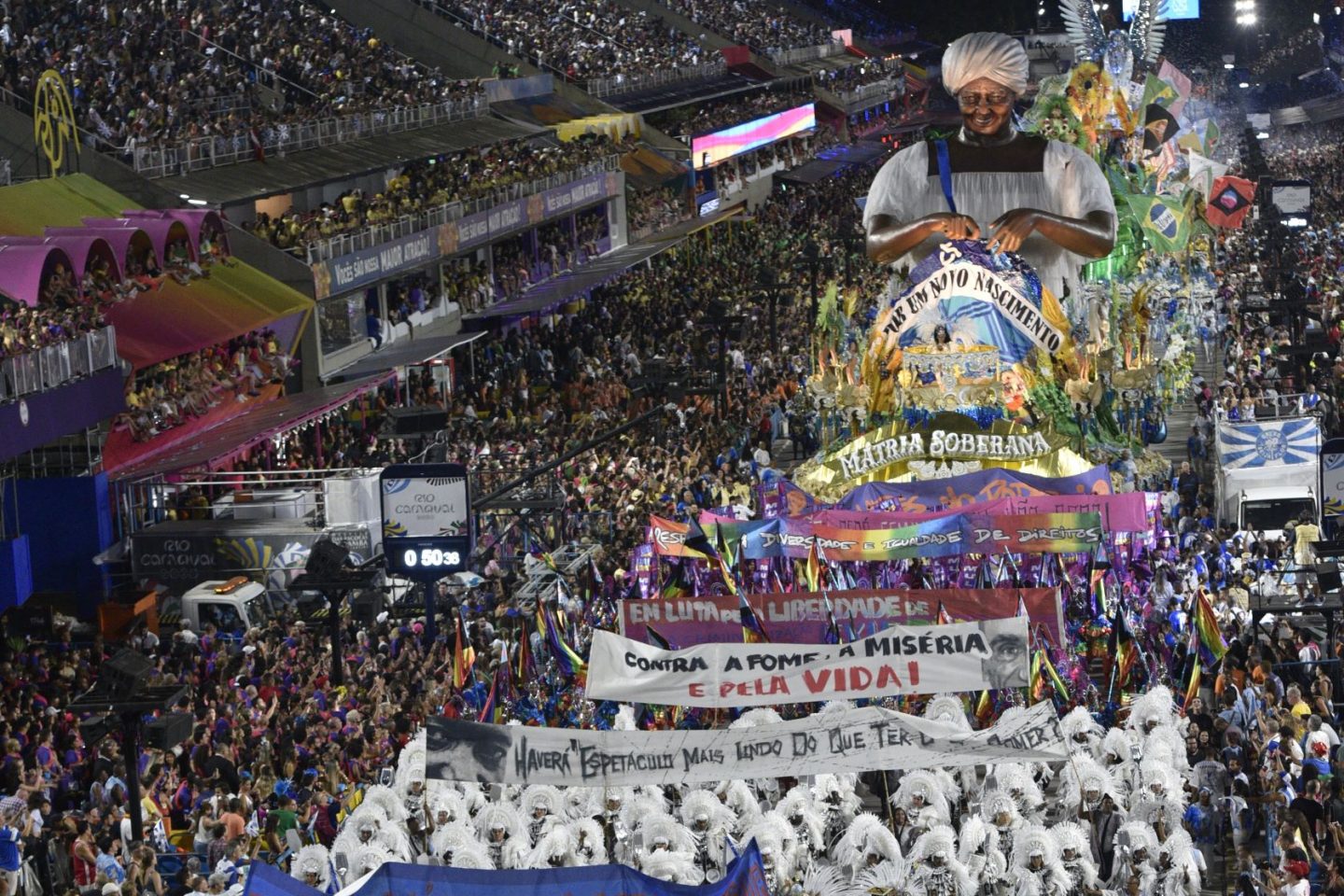 eija-Flor com suas faixas de protesto e a alegoria com a confecção de uma nova bandeira do Brasil: sucesso da escola mostra força de desfile politizado (Foto: Ismar Ingber / Riotur)
