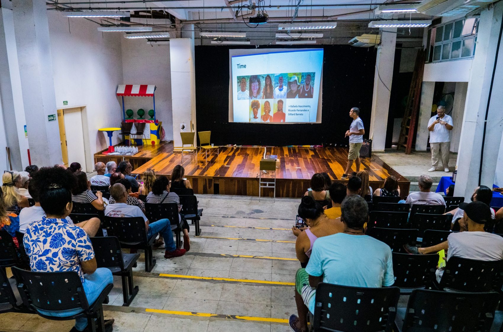 No palco, Michel Silva, cofundador do Fala Roça, apresenta a equipe envolvida no estudo durante lançamento do Mapa Cultural da Rocinha. Foto: @davidsouzafilmes/Fala Roça