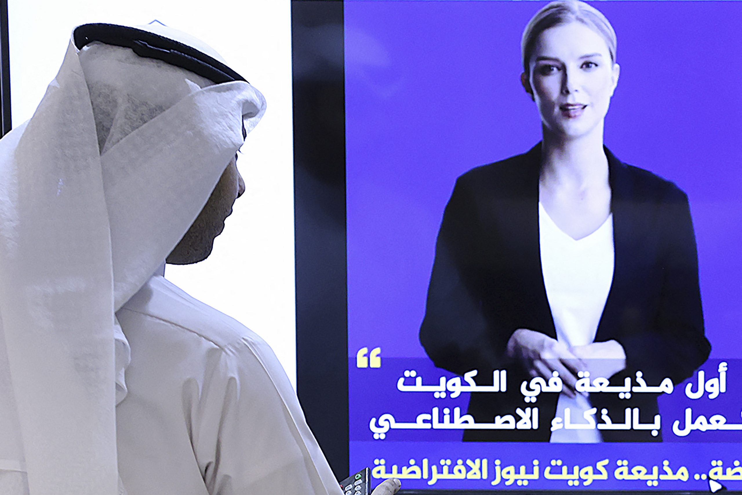 Jornalista assiste, no Kuwait, ao vídeo de Fedha, apresentadora criada por inteligência artificial. Foto Yasser Al-Zayyat/AFP