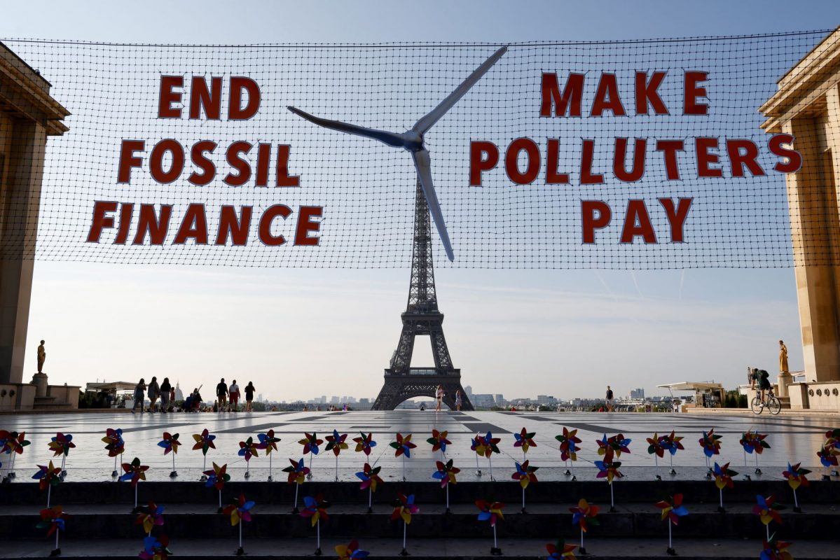 Ativistas fazem ato na Torre Eiffel para protestar contra financiamento a combustíveis fósseis: crise climática é desafio para Cúpula de Paris (Foto: Ludovic Marin / AFP)