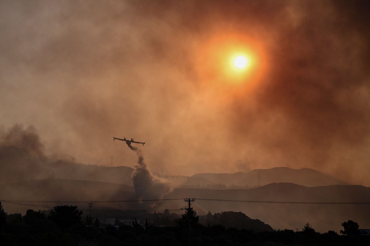 Avião combate incêndio florestal na Ilha de Rhodes, na Grécia, onde calor está acima de 40: julho será o mês mais quente da história, alerta a ONU (Foto: Spyros BAKALIS / AFP - 25/07/2023)
