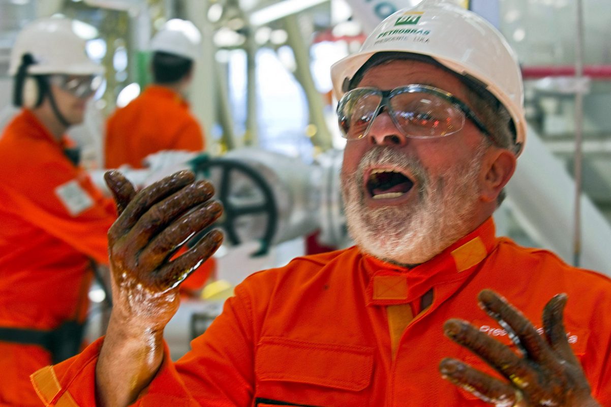O presidente Lula grita de alegria mostrando as mãos sujas com a primeira extração de petróleo do Pré-sal, em Angra dos Reis. Foto Antonio Scorza/AFP/ Outubro/2010