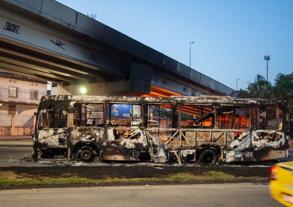 Carcaça de ônibus queimado no Rio: número de mortes em conflitos armados dobrou na Zona Oeste em 2023 (Foto: Bruno Kaiuca / AFP) 