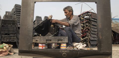 Homem tenta reciclar uma televisão em um ferro-velho em Dhaka, Bangladesh. Foto Kazi Salahuddin Razu/NurPhoto via AFP