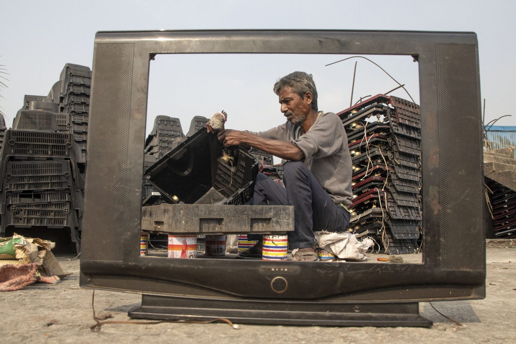 Homem tenta reciclar uma televisão em um ferro-velho em Dhaka, Bangladesh. Foto Kazi Salahuddin Razu/NurPhoto via AFP