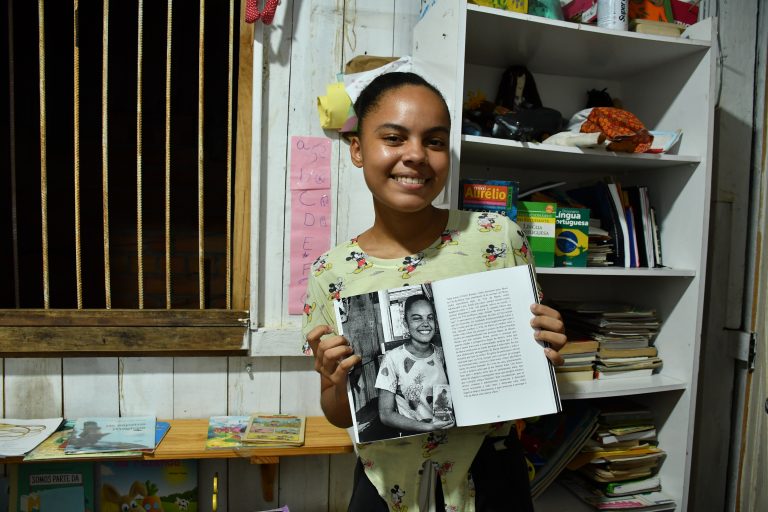 Emily Raiane, 17 anos, na Barca Literária, mostra o livro do qual participou como autora do posfácio. Foto João Paulo Guimarães