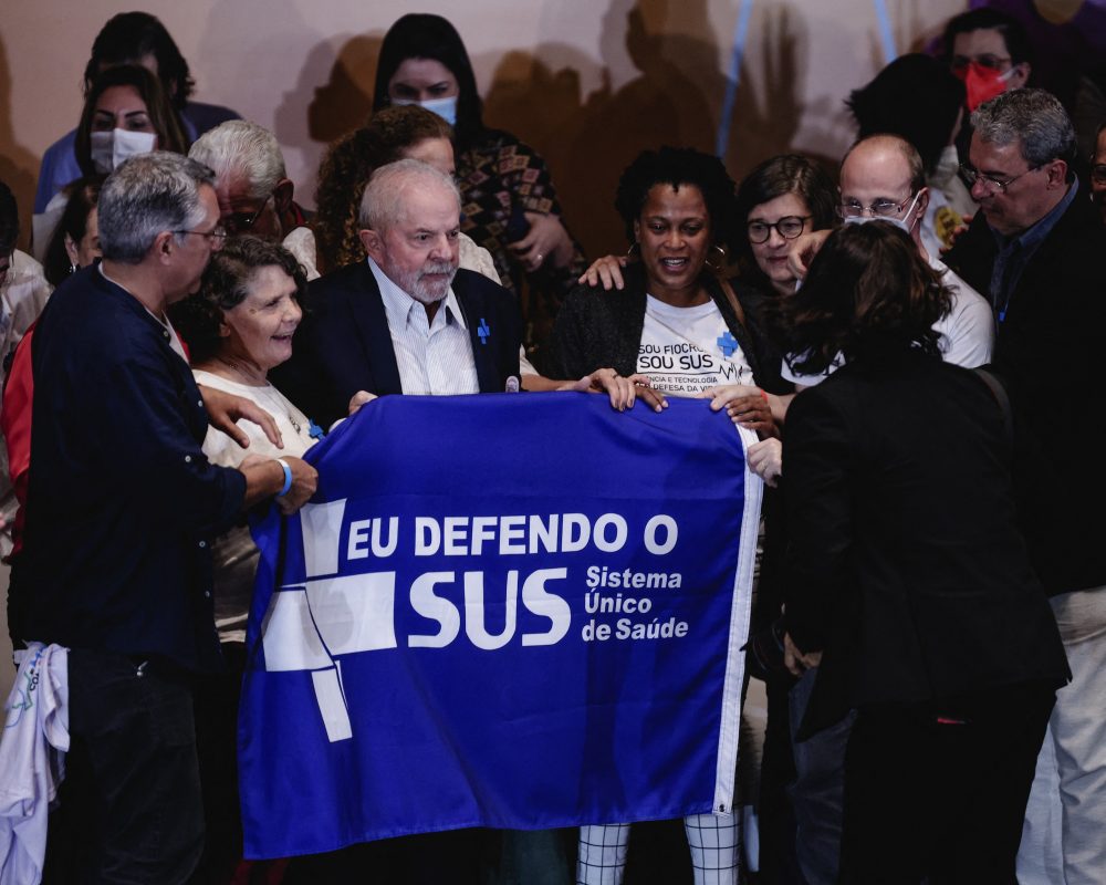Presidente Lula e apoiadores posam com uma faixa em defesa do Sistema Único de Saúde. Foto Ettore Chiereguini/AGIF via AFP