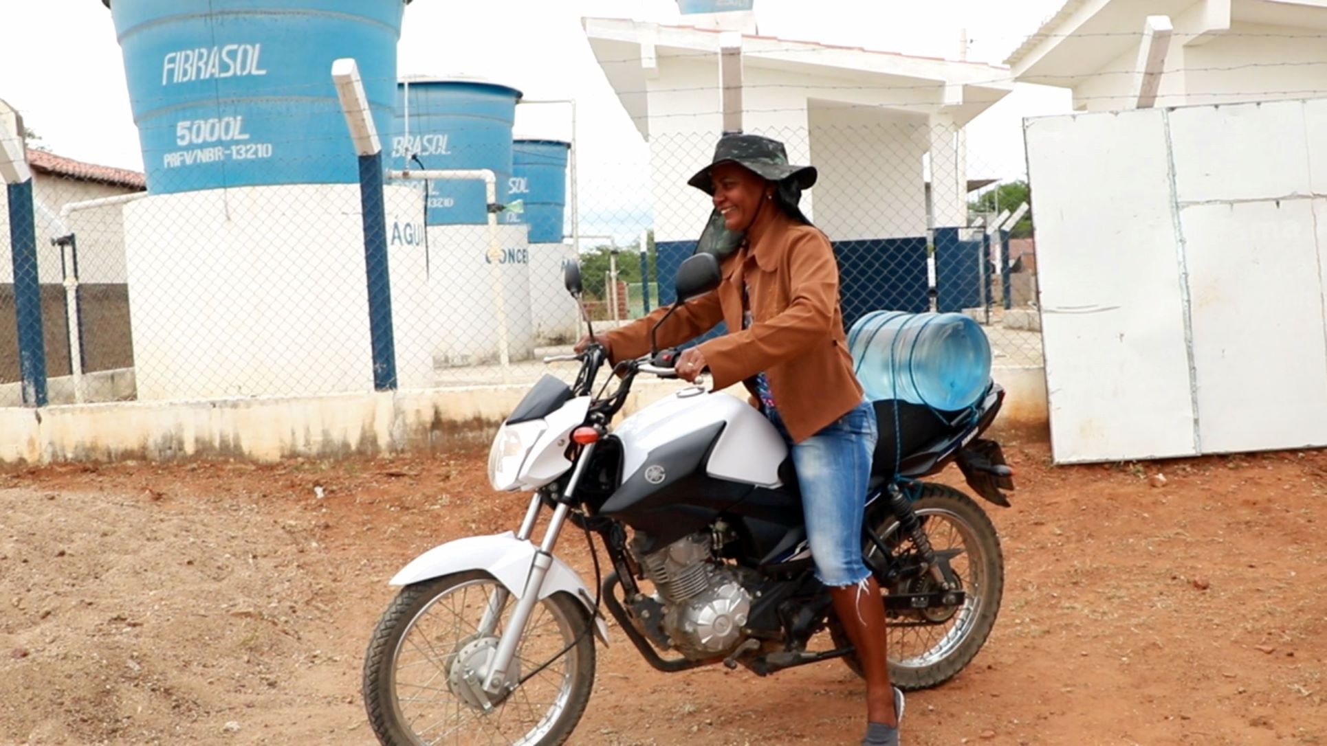 Moradora de Arapuá Novo, no Semiárido baiano, leva galão de água para casa: comunidade faz fila duas vezes por semana para ter garantia de água potável (Foto: Irpaa)