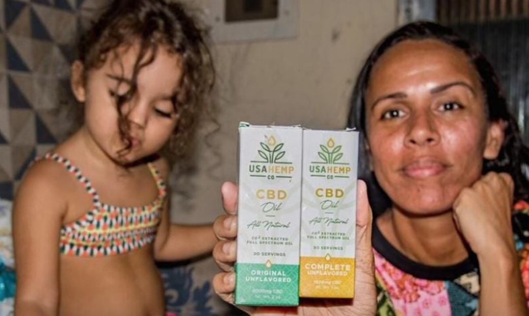 Rafaela com a filha, Maria Antonella, e óleo de cannabis: uso terapêutico de maconha no tratamento do autismo (Foto: Selma Souza / Voz das Comunidades)