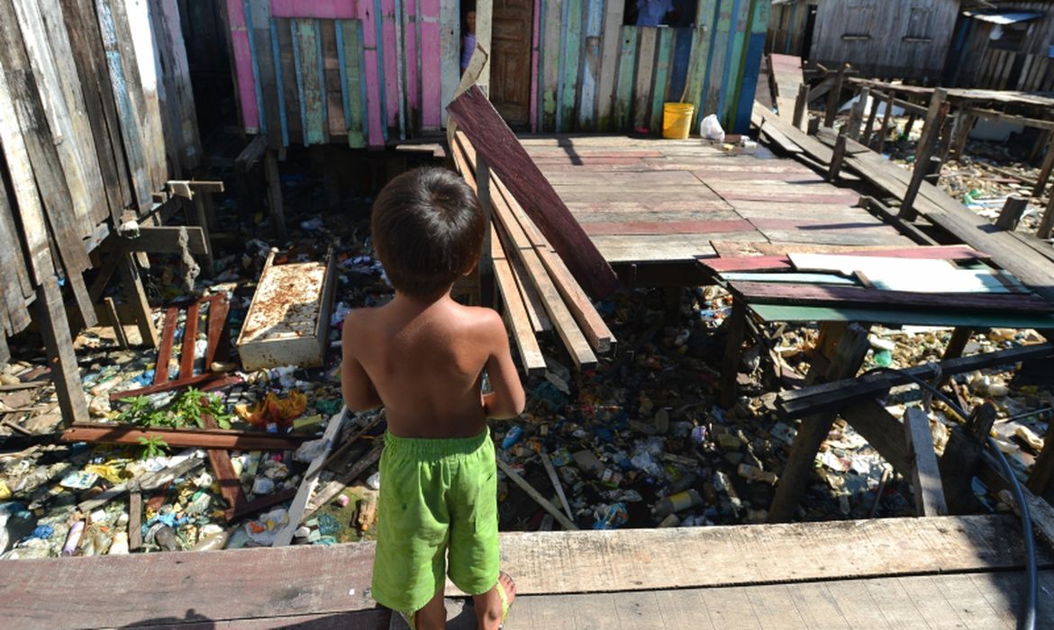 Menino em área sem acesso à rede de esgoto no Complexo da Maré, no Rio: levantamento indica que 41,7% das crianças de 0 a 5 anos não têm acesso a saneamento em seus domicílios (Foto: Marcello Casal Jr. / Agência Brasil)