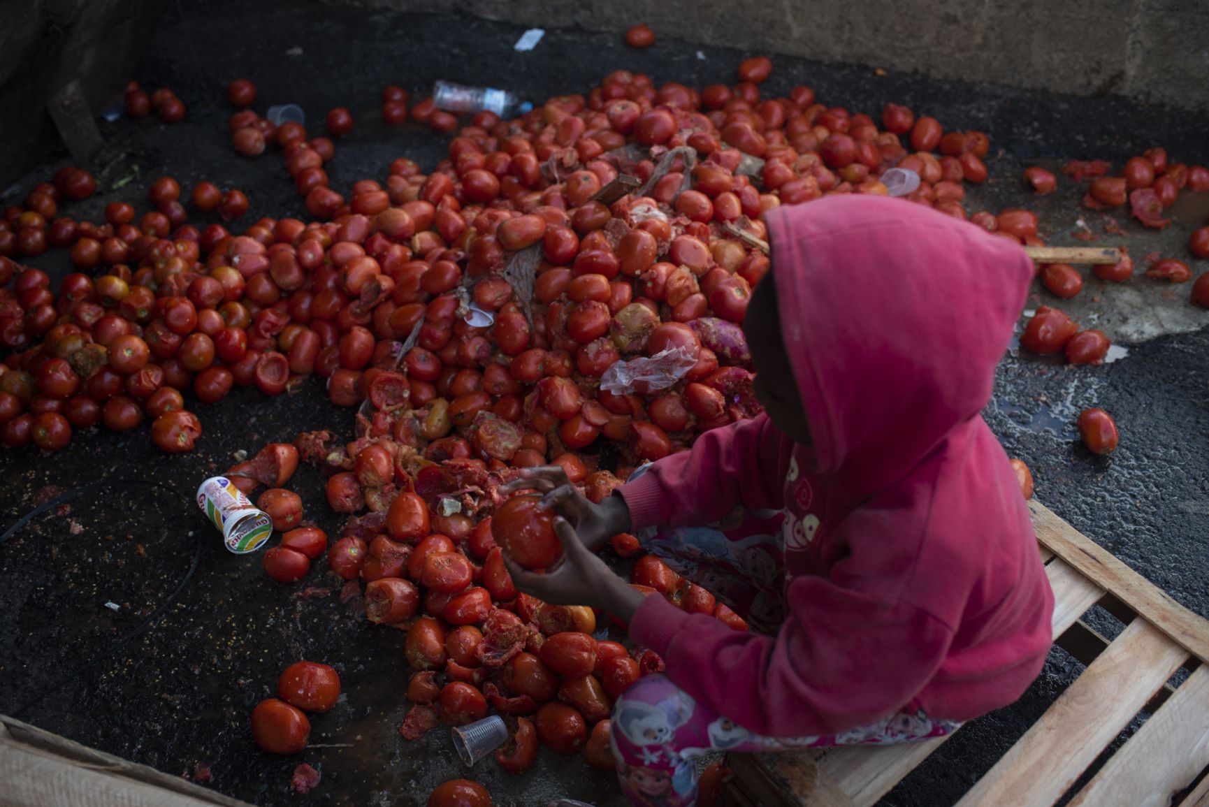 Menina pega tomate na xepa de feira no Rio: má alimentação na infância tem impacto por toda a vida (Foto: Fábio Teixeira / AFP - 19/08/2021)