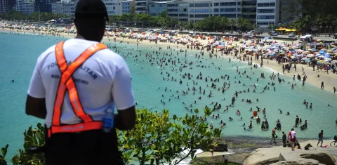 Do alto da pedra do Arpoador, policial militar acompanha a movimentação na praia. Foto Divulgação PM