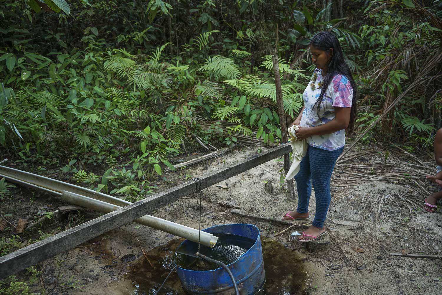 Moradora da aldeia de Branquinho, em Manaus, observa um dos únicos poços ainda com água potável nas redondezas. A seca causa transtornos e isola comunidades ribeirinhas. Foto Juliana Pesqueira / Amazônia Real, CC BY-NC-ND