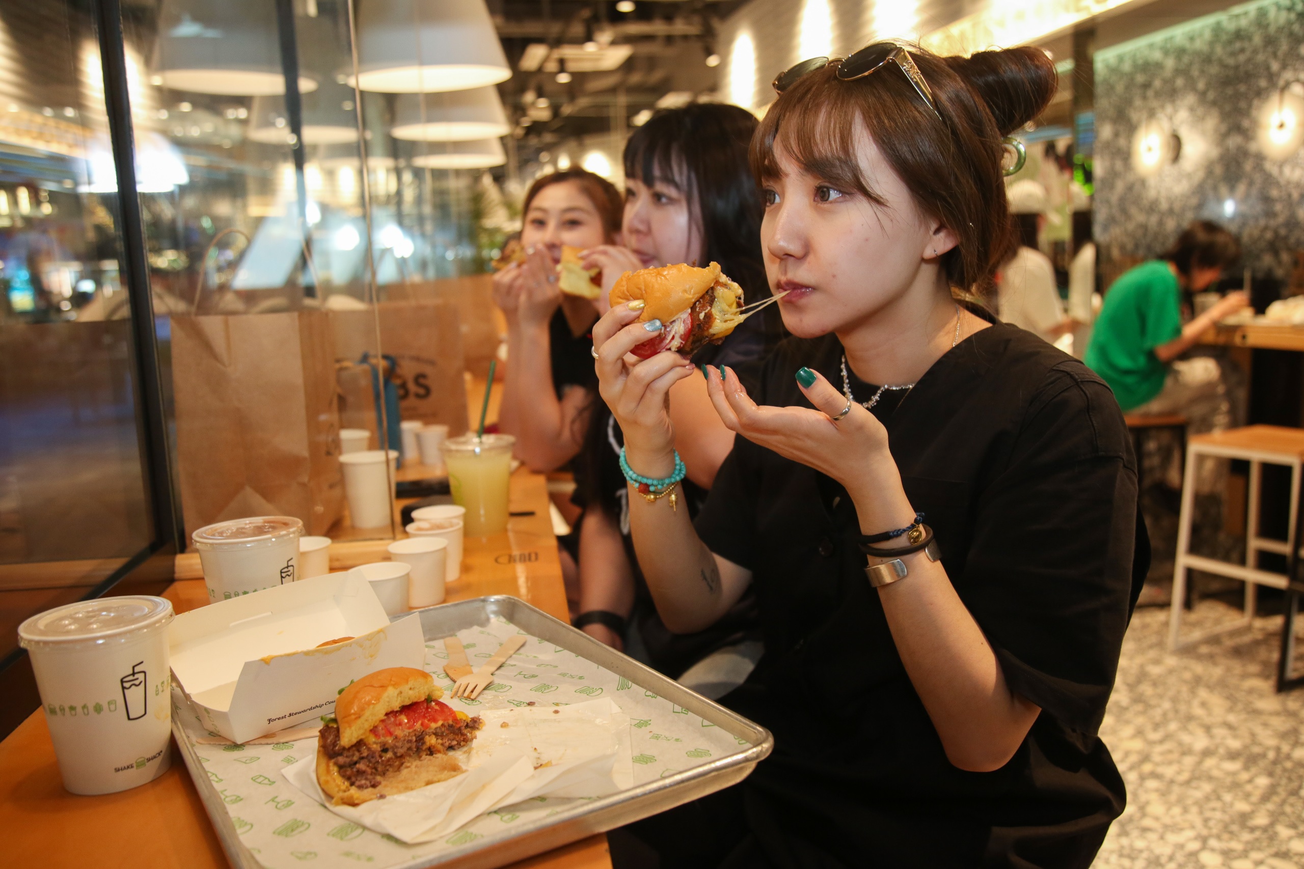 Yang Lan e suas irmãs comem hambúrguer em um bairro nobre em Beijing. Foto Xiao Ye / Diálogo Chino
