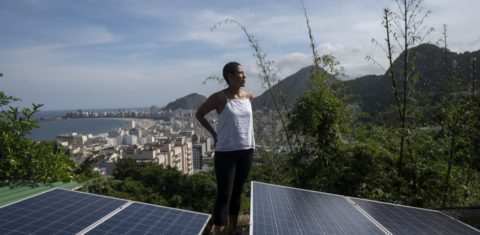 A colombiana Bibiana Angel, proprietária do albergue Eco Pousada Estrelas da Babilonia, posa em sua cobertura repleta de painéis solares e com vista para a praia de Copacabana, na favela Babilonia, zona sul do Rio. Foto Mauro Pimentel/AFP
