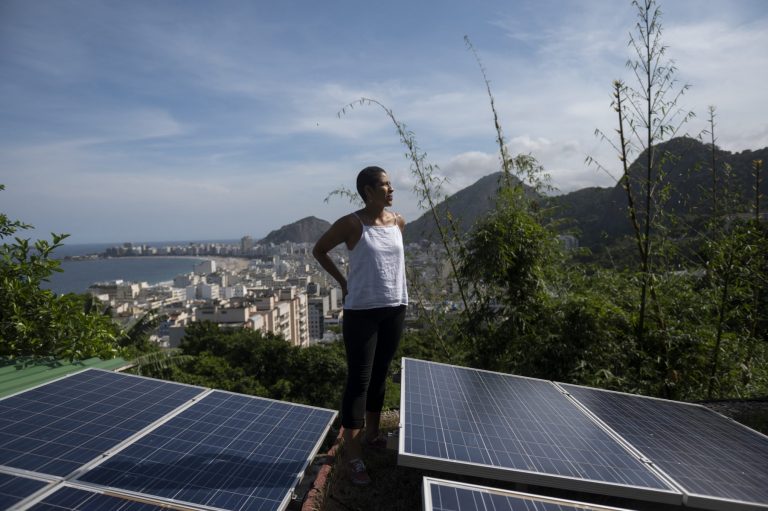 A colombiana Bibiana Angel, proprietária do albergue Eco Pousada Estrelas da Babilonia, posa em sua cobertura repleta de painéis solares e com vista para a praia de Copacabana, na favela Babilonia, zona sul do Rio. Foto Mauro Pimentel/AFP