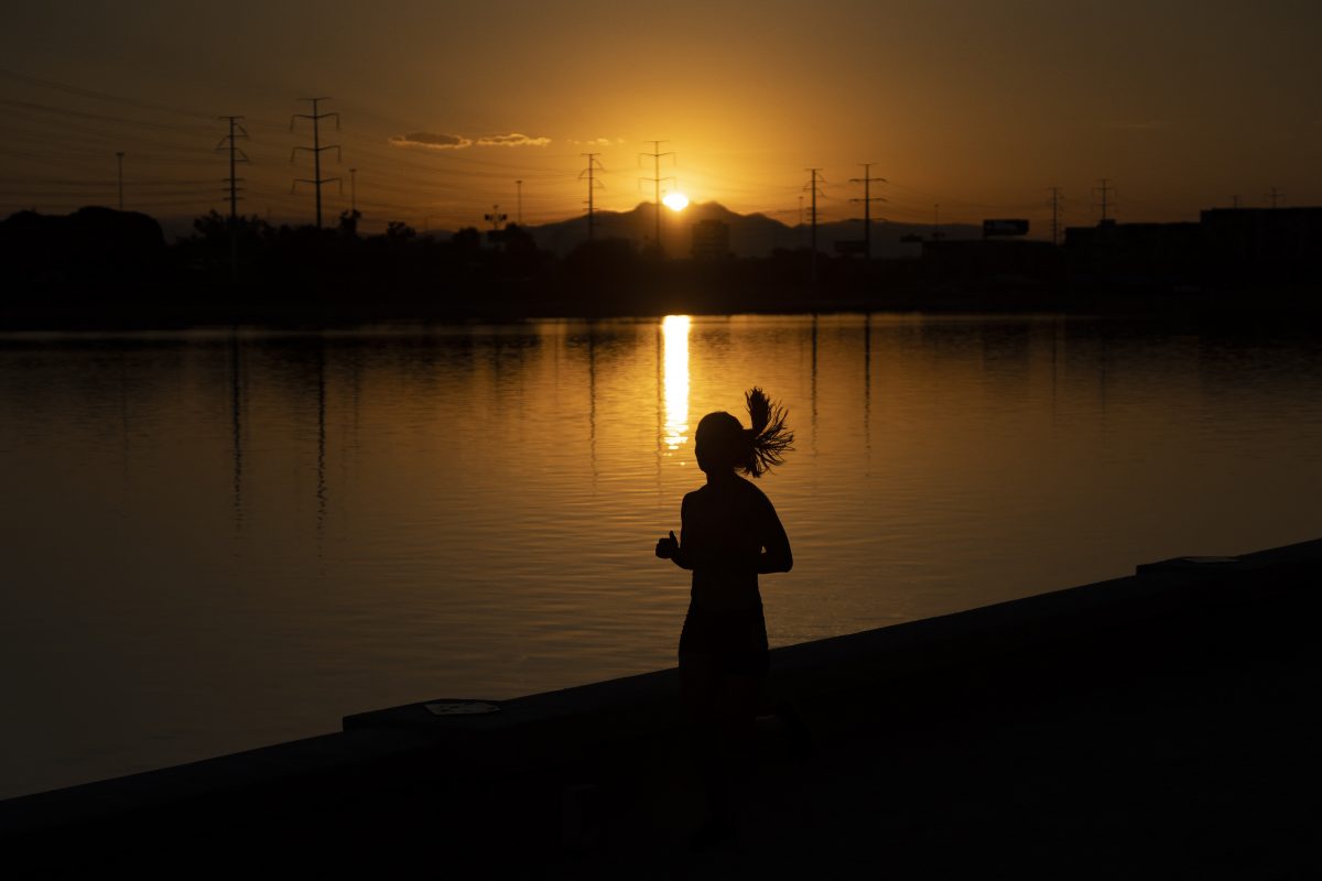 Uma mulher corre no nascer do sol em Tempe Town Lake, no Arizona. Há 12 dias a região registra recordes de calor em torno de 43º Celsius. Foto Rebecca Noble/ Getty Images via AFP. Julho/2023