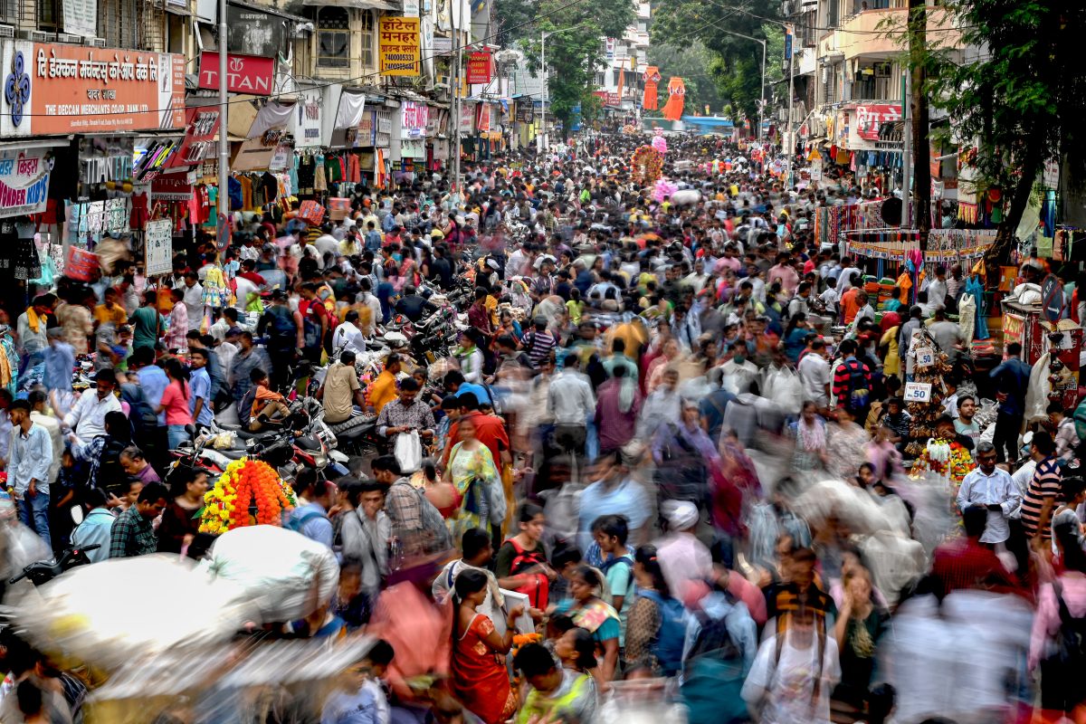 Em Mumbai, pessoas caminham por um mercado para fazer compras de última hora antes do Diwali, festa religiosa hindu. Foto Indranil Mucherjee/AFP
