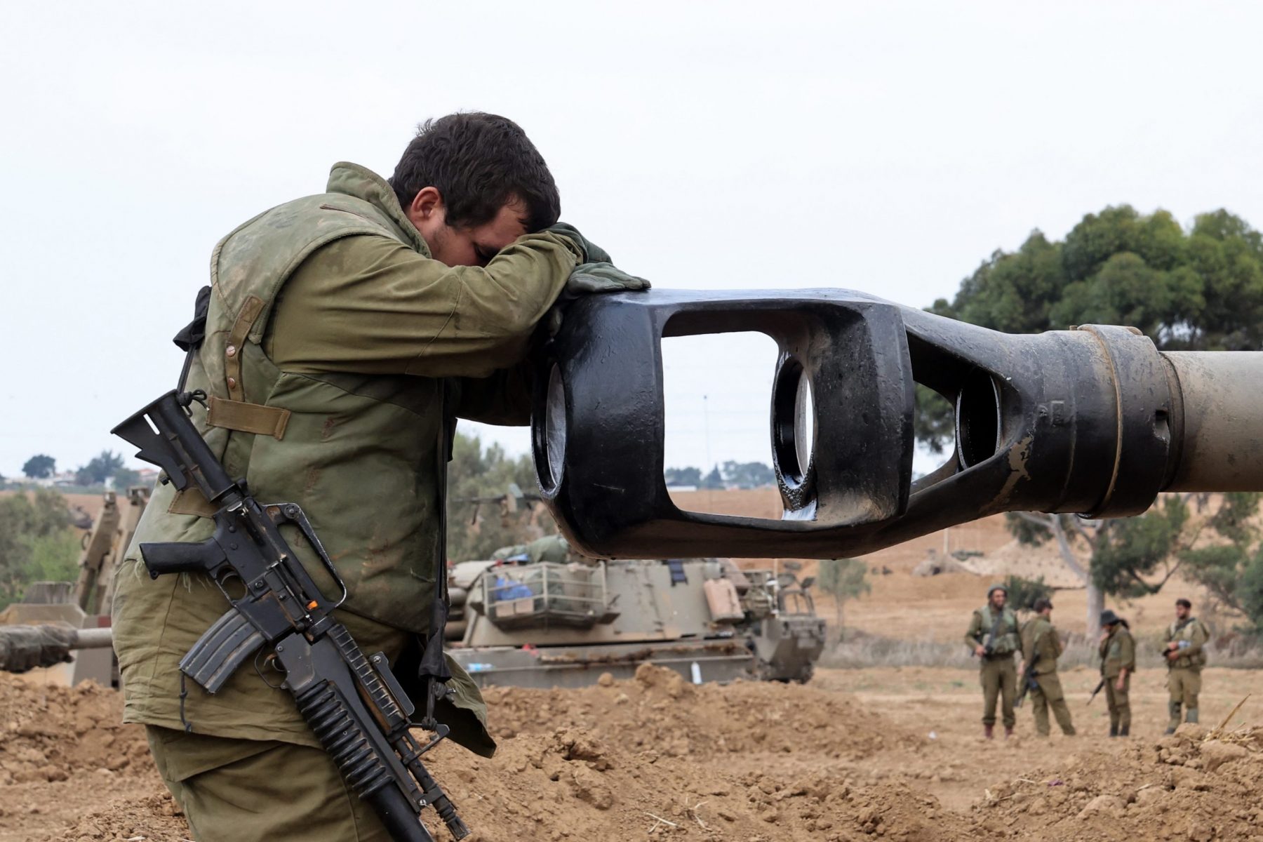 Soldado israelense apoia a cabeça no cano de um obus de artilharia autopropelida enquanto soldados israelenses tomam posições perto da fronteira com Gaza, no sul de Israel. Foto Jack Guez/AFP. Em 9 de outubro de 2023