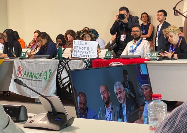 Em reunião com o presidente na COP28, em Dubai, Txai Paiter Suruí segura uma placa pedindo providências do governo. Foto Raylson Santos