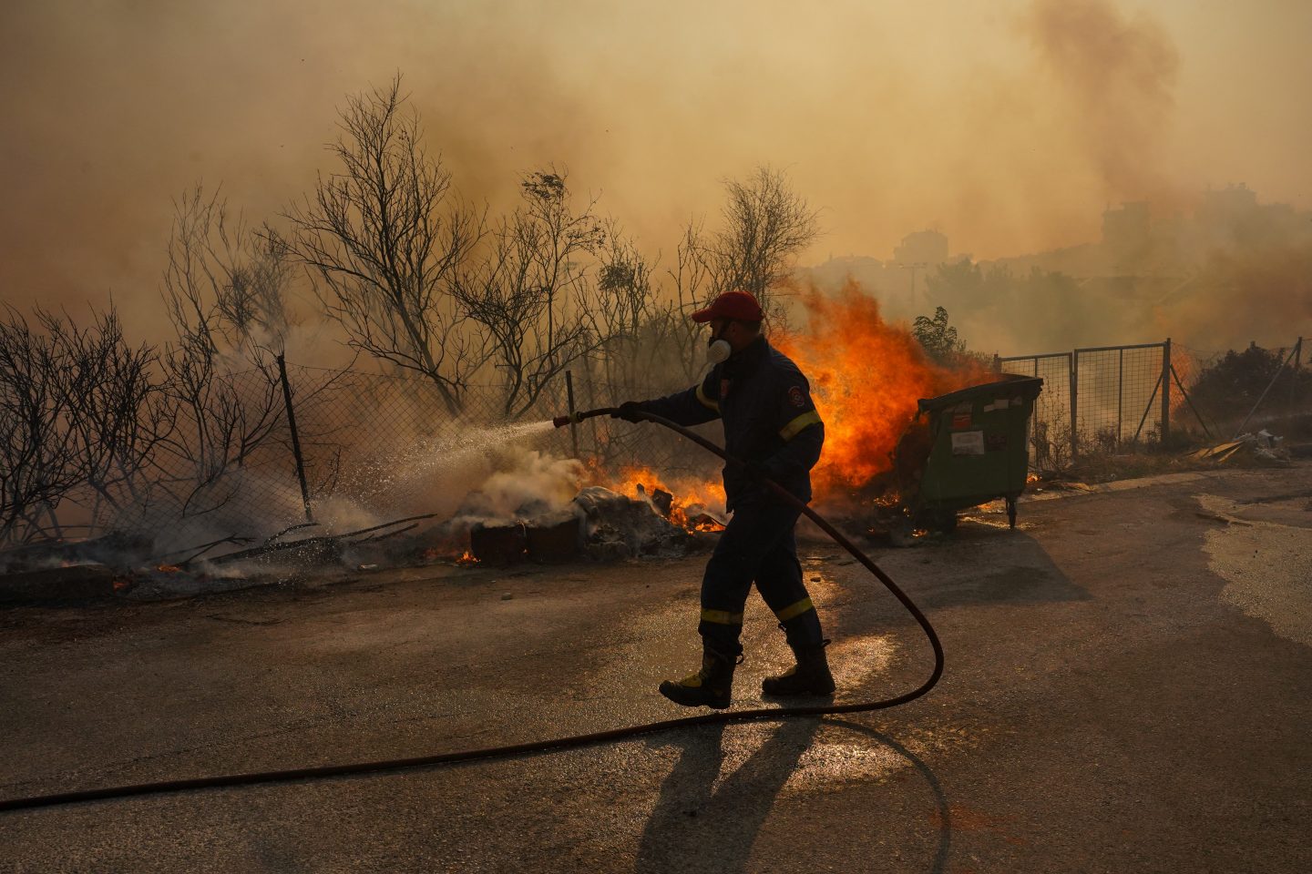 Na onda de calor que atinge a Europa, bombeiro combate um incêndio na área urbana do sul de Ática, na Grécia. Foto Giorgos Arapekos/NurPhoto via AFP. Julho/2023