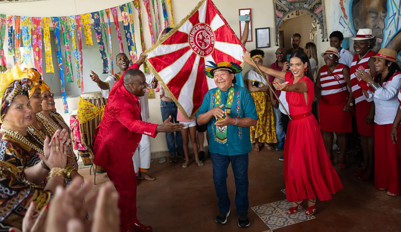 Davi Kopenawa entre o mestre-sala Sidclei e a porta-bandeira Marcella em visita à escola de samba: "O Salgueiro vai falar pelo nome do meu povo" (Foto: Lucas Landau / ISA - 11/10/2023)