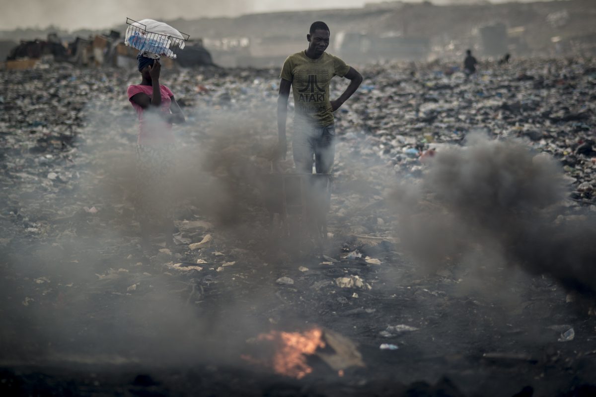 Jovem queima lixo eletrônico no lixão de Agbogbloshie, em Accra, capital de Gana. O lixão está localizado na favela de Agbogbloshie, um antigo pântano e lar de refugiados que fugiram do conflito no norte de Gana durante a década de 80. Foto de Cristina Aldehuela/AFP