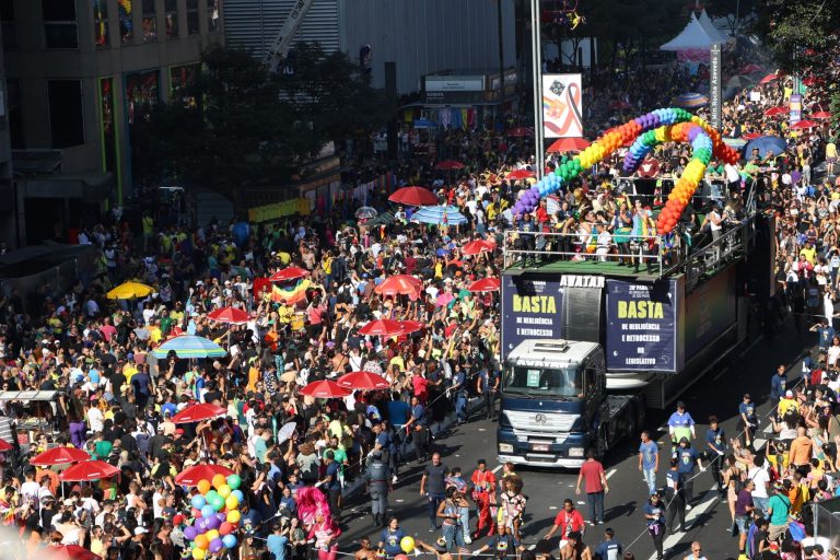 Multidão acompanha 28ª Parada do Orgulho LGBT+ em São Paulo, seguindo trio elétrico com a mensagem "Basta de Negligência e Retrocesso": defesa dos direitos (Foto: Rovena Rosa / Agência Brasil)