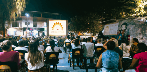 Exibição de filme pelo CineSolar em Belo Oriente (MG): dois furgões com placas fotovoltaicas no teto e sistema conversor de energia para levar cinema ao interior do Brasil (Foto: Pedro Cerqueira / Cine Solar - 20/03/2023)
