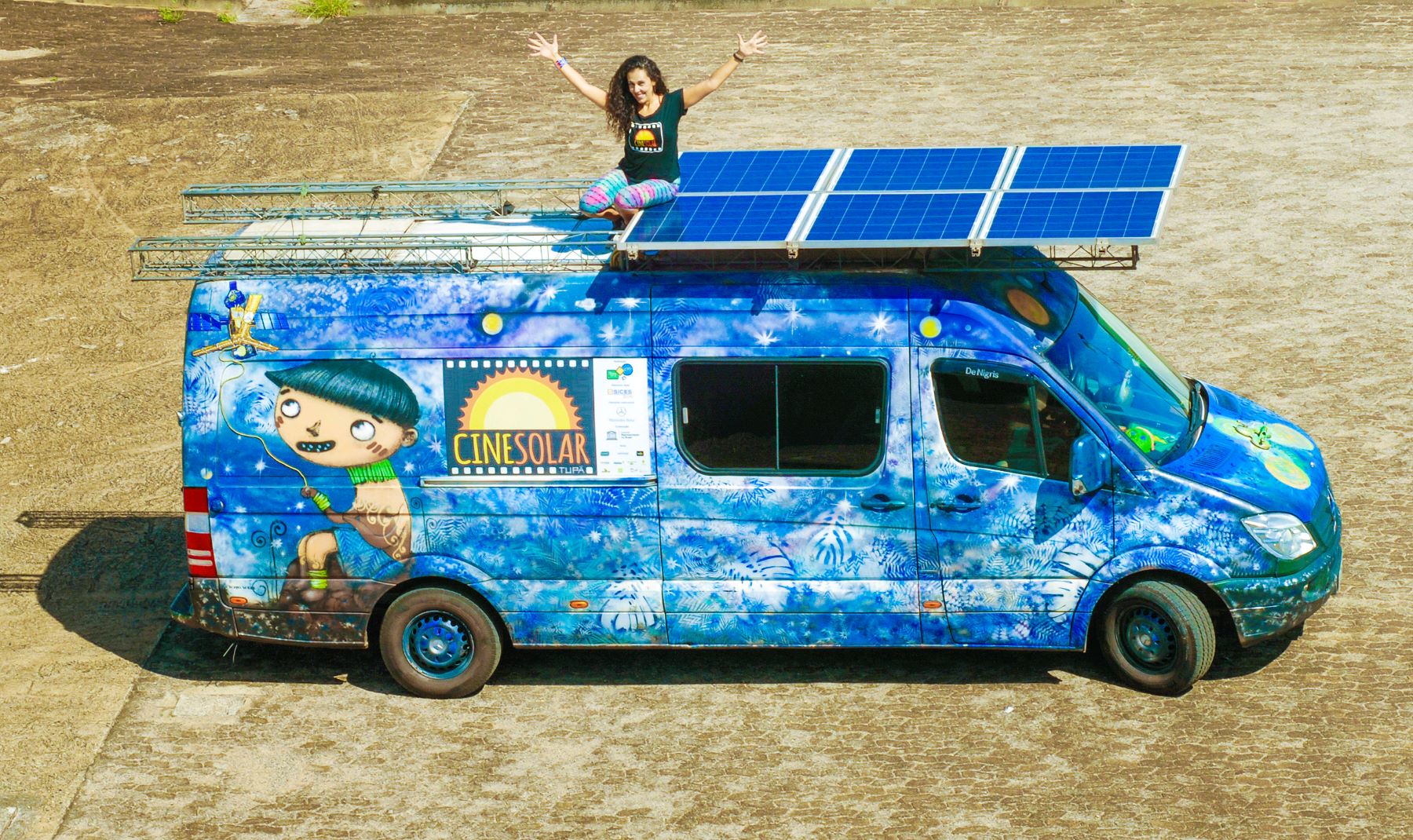 A produtora Cybthia Alario com a van do CineSolar e suas placas fotovoltaicas: cinema com energia limpa e renovável (Foto: Divulgação)