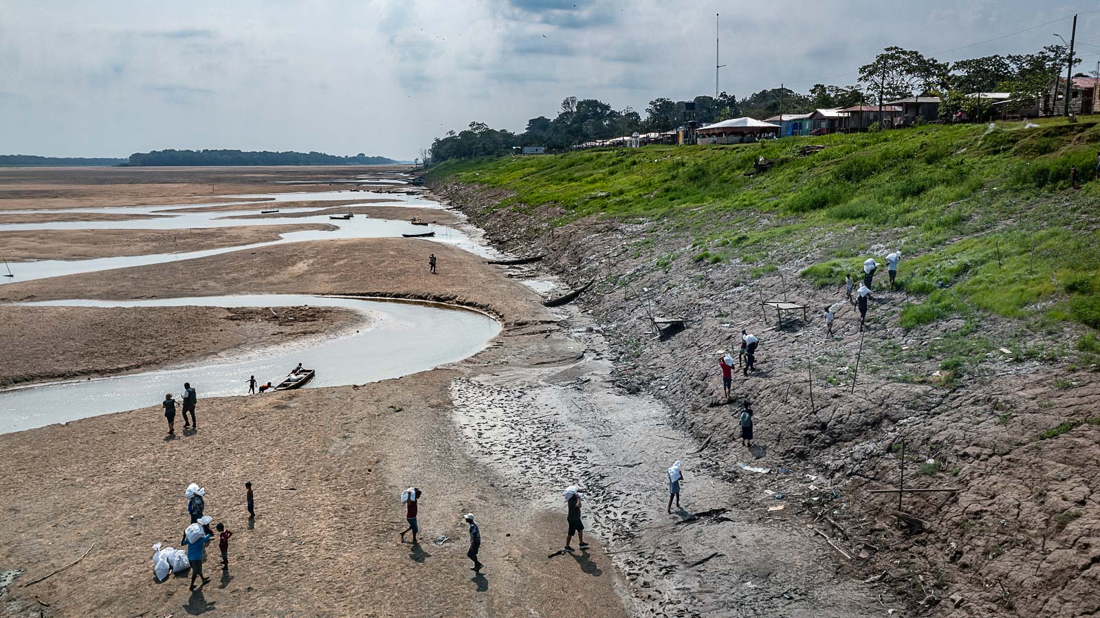 Doações chegam à comunidade de Porto Praia, do povo indígena Kokama durante a seca extrema de 2023: cientistas projetam problemas agudos de abastecimento de água, ondas de calor e queimadas acidentais em áreas agrícolas e incêndios florestais (Foto: Marizilda Cruppe / Greenpeace - Outubro de 2023)