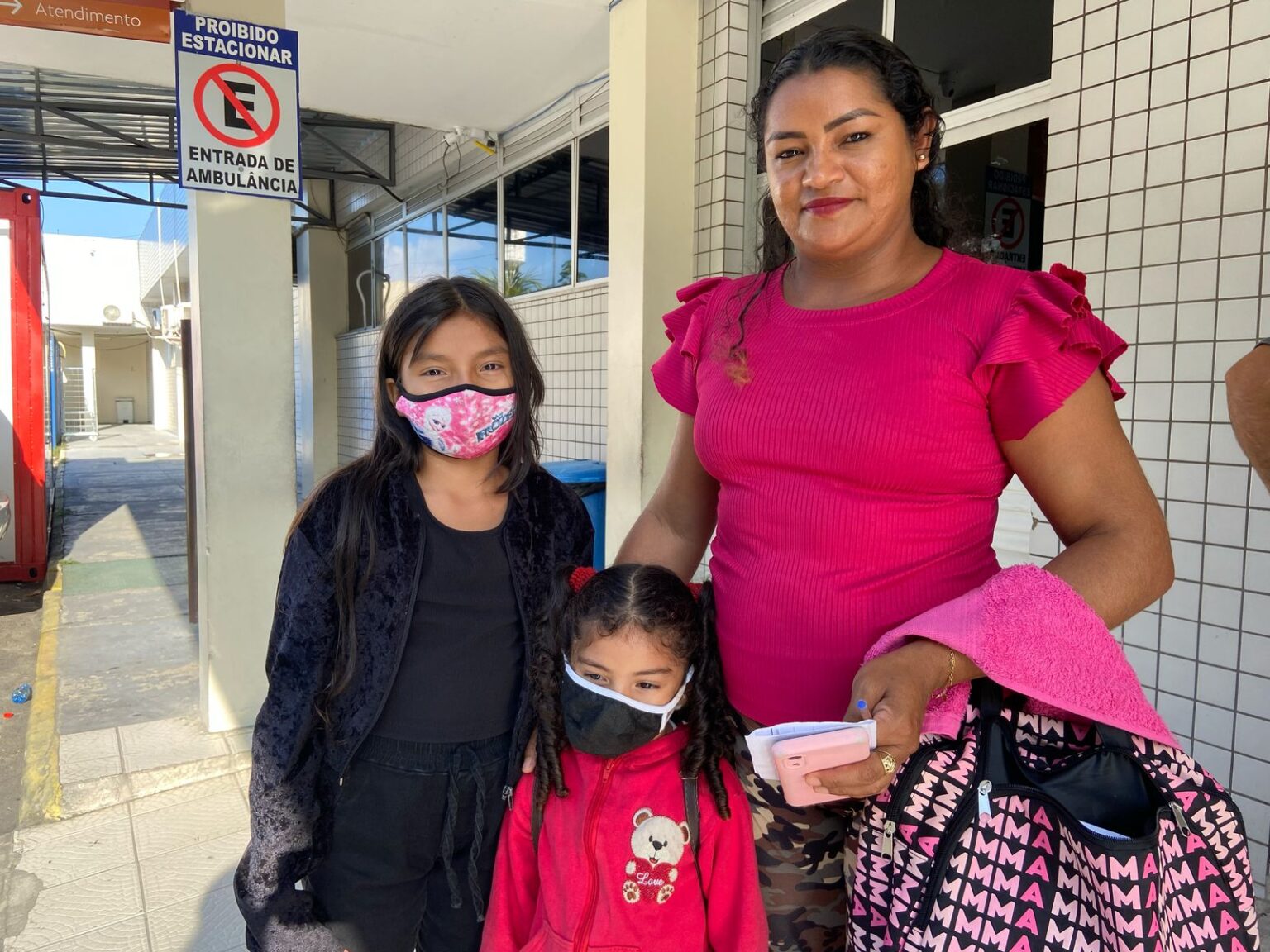 Miriam Galvão da Silva com as filhas Ana Gabriela e Maria em frente à UBS, em Manaus: aumento de casos de doenças respiratórias (Foto: Leanderson Lima/Amazônia Real)