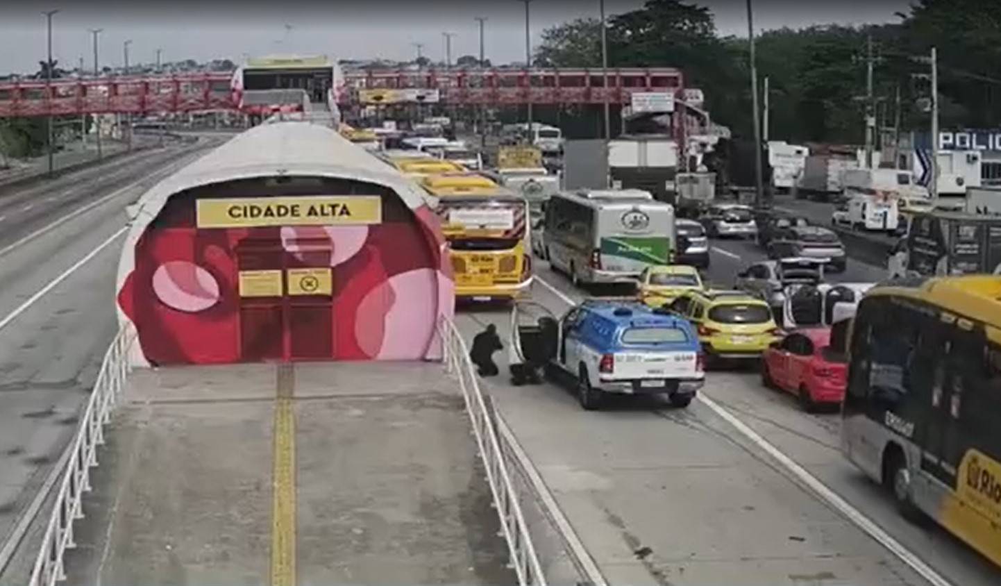 Policiais se protegem dos tiros na Avenida Brasil parada: três trabalhadores mortos na principal via expressa do Rio (Foto: Reprodução / TV Globo)