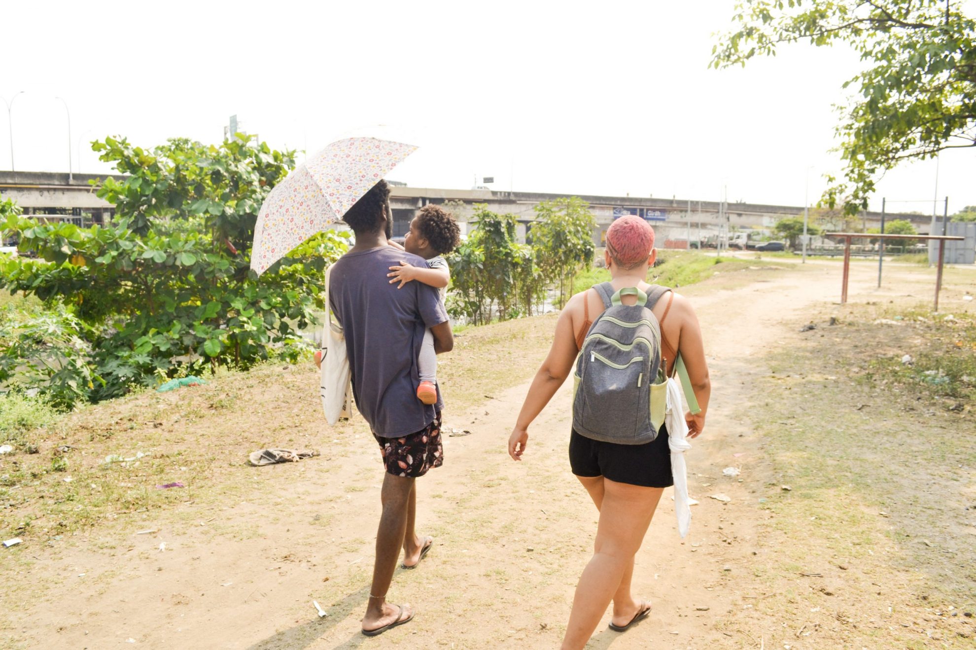 Para levar a filha Tereza, de 1 ano e meio, até a creche, o casal Milena e Mathaus enfrentam o calor e os desafios dos espaços urbanos hostis no trajeto. Foto Suellen Paim de Melo (Instagram @susuclica)