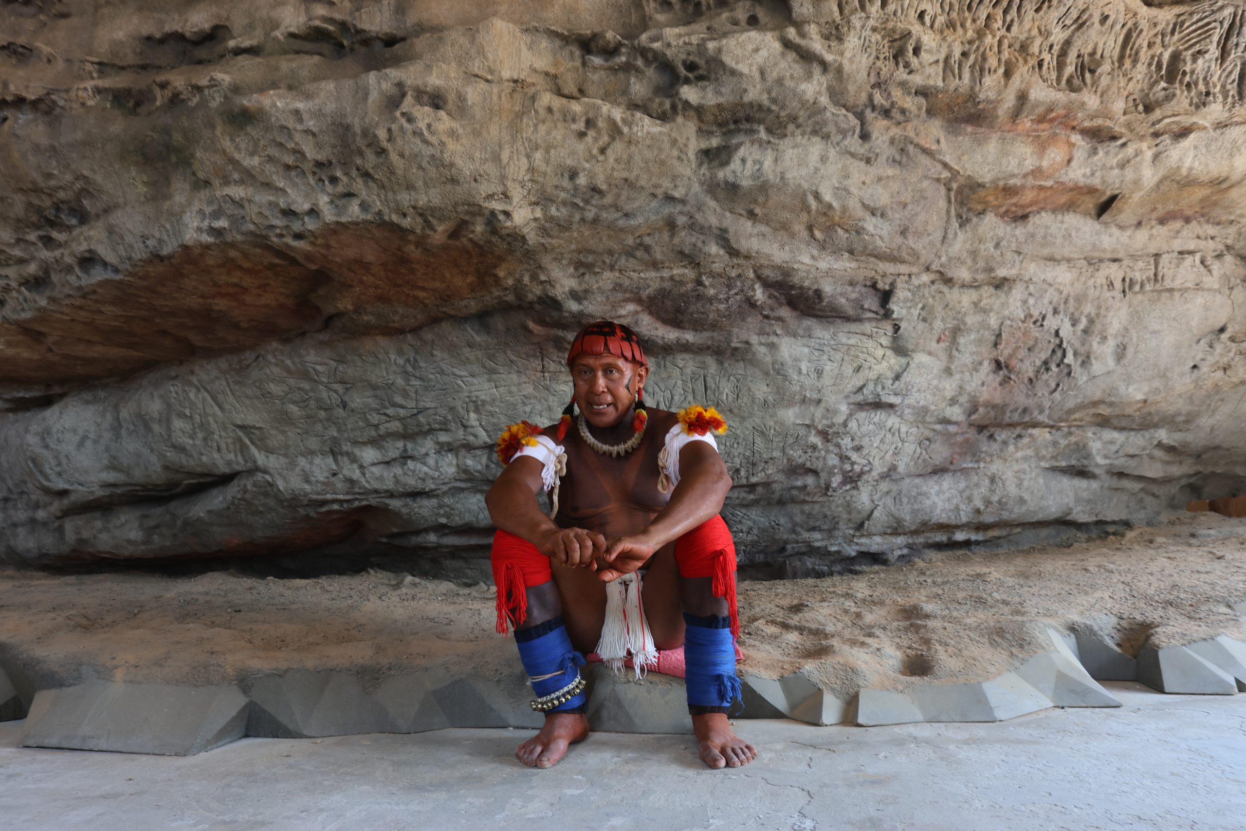 Akari Waurá, cacique da aldeia Topepeweke, uma das nove comunidades do povo Wauja, em frente a réplica em 3D da gruta de Kamukuwaká. (Alaor Filho/ Fotos Públicas)