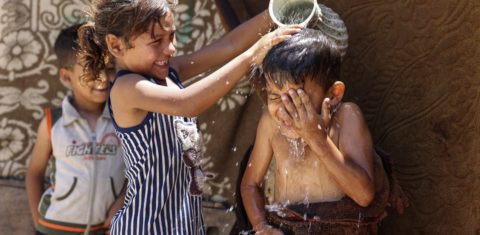 Crianças se refrescam em meio as altas temperaturas e os cortes de energia na cidade de Gaza, na Palestina. O ano de 2023 está sendo o mais quente dos últimos 12 mil anos. Foto Mohammed Abed/AFP