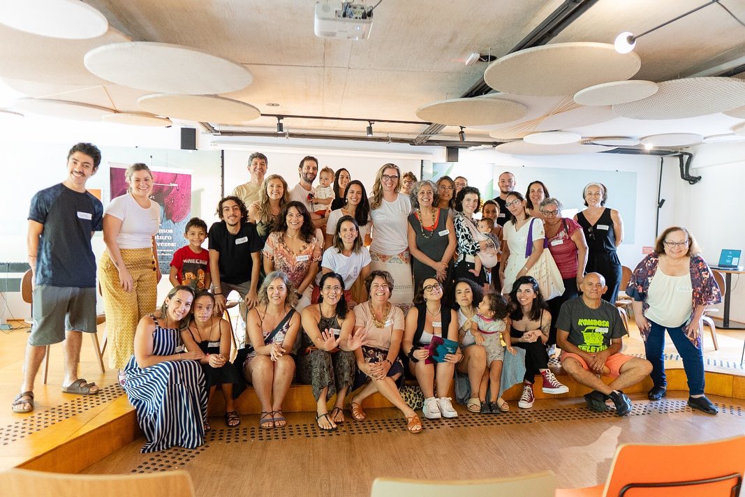 Foto colorida de grupo reunido durante evento do Mães pelo Clima. Diversas pessoas aparecem perfiladas e olhando para a foto, a maioria são mulheres